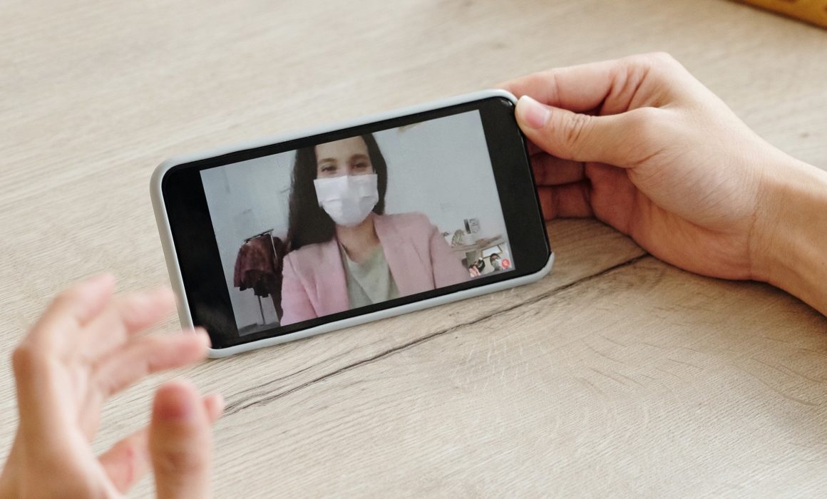 Doctor in mask conducting a video consultation